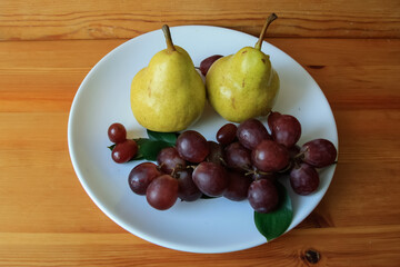 Two yellow pears and purple grapes.