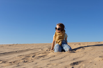 Little kid girl in goggles in sand desert after apocalypse. - 423671686