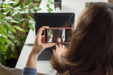 A woman photographer takes photo of a workplace on the phone. Freelance