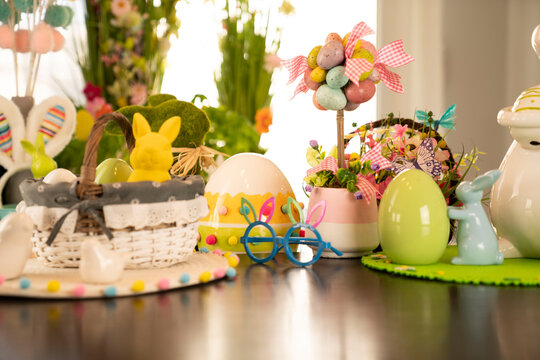 Easter decorations in the house. Easter bunny, easter eggs in basket and cabbage leaf. Bouquets of spring flowers. 