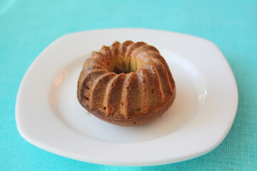 A small shaped cupcake on a white plate.