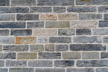 Minimalist textured monochrome background of old grey bricks and stones in horizontal display on an old wall in Scotland.