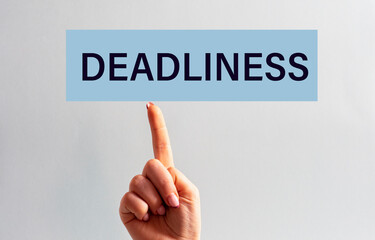 The woman's index finger of the hand is directed to the sign with the inscription - DEADLINESS