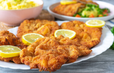 Pork schnitzels on a plate on kitchen table. Homemade cooked