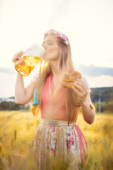 Woman in traditional clothing drinking beer in Bavaria