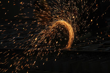 Steel cutter grinder and sparks in workshop.
