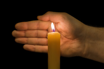 Hand and burning candle