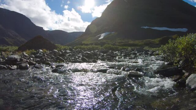 A cold stream on a sunny day next to some big mountains. Close to Silverfallet and Kebnekaise, Sweden.
