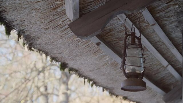 50 FPS Ancient Old Lantern Hangs on a Moss Roof on a Bright Spring Day