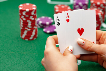 Female holding playing cards, playing poker at green table