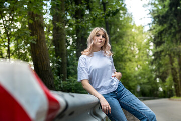 young lady in jeans and a white T-shirt has a great time in nature in the woods