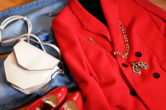 Modern Woamn Outfit With Red Jacket And Jeans And White Geometic Bag