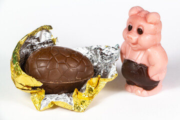 Chocolate eggs wrapped in golden paper and pig for Easter