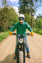 Young man with helmet riding a custom motorbike outdoors