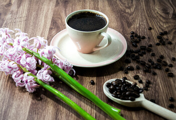 Coffee beans on black rustic background with hyacinth. Top view with copy space for your text