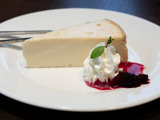 白いお皿に盛り付けられたいちごソースのチーズケーキ