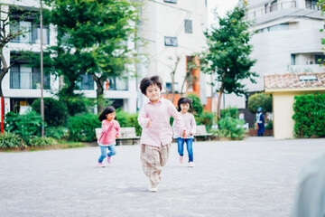 公園でかけっこをする小さな子どもたち