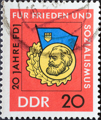 GERMANY, DDR - CIRCA 1966  : a postage stamp from Germany, GDR showing the badge of the organization Free German Youth (FDJ) as a symbol for good knowledge. 20 years FDJ