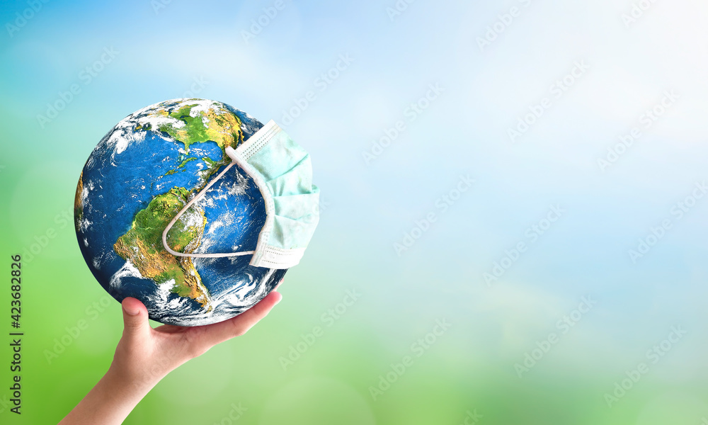 Wall mural earth day concept: human hand holding earth globe over blurred green and blue nature background. ele