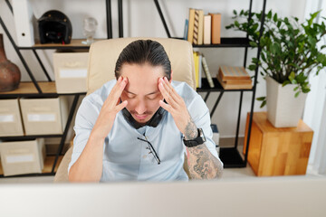 Entrepreneur suffering from headache after working on big project all day long without breaks