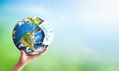 Earth day concept: human hand holding earth globe over blurred green and blue nature background. Elements of this image furnished by NASA