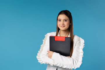 Caucasian young business woman with folder of documents isolated on blue studio background. Young entrepreneurship concept.