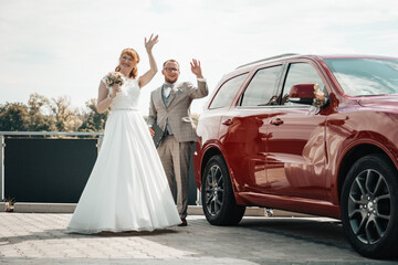 Bridal couple waving on their wedding day