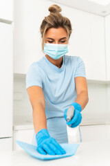 Fototapeta na wymiar Woman worker wearing prevention mask and gloves during apartment cleaning