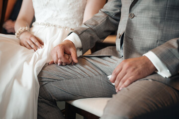 Obraz na płótnie Canvas Groom and bride holding hands during wedding ceremony