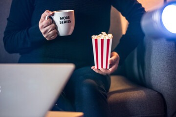 Home Cinema. Watching tv series with a cup of tea that say more series and pop corn