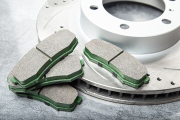 brake pads and perforated brake discs on a stone gray table
