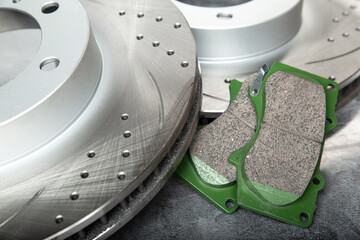 brake pads and perforated brake discs on a stone gray table