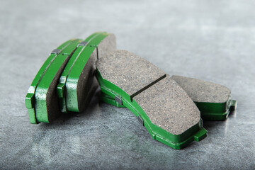 a set of new green brake pads on a gray table