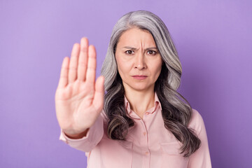 Portrait of attractive trendy elderly retired pensioner depressed offended woman showing palm stop...
