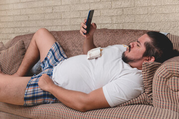 A lazy and overweight bum munches on some french fries while watching a video or browsing social...