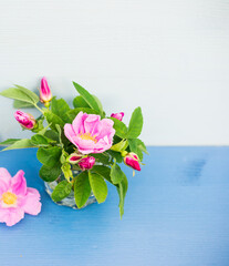 Tiny bouquet of roses on an blue wooden table. Floral background