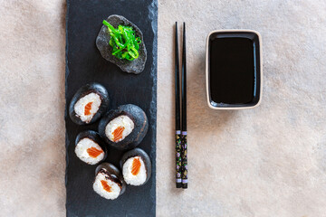 Japanese sushi served on black stones. Top view, close up on dark background..