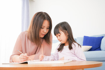 お母さんと一緒にお勉強をする小さな女の子