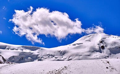 Fototapeta na wymiar Giant mountain glaciers against a blue sky with clouds
