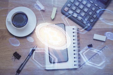 Double exposure of blockchain theme hologram over table with phone. Top view. Crypto technology concept.