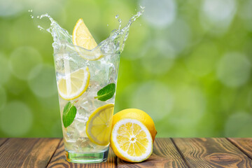 lemonade in glass on wooden table with green blurred background