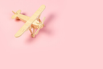 wooden model of a passenger plane with on a pink background. tourism and travel concept.