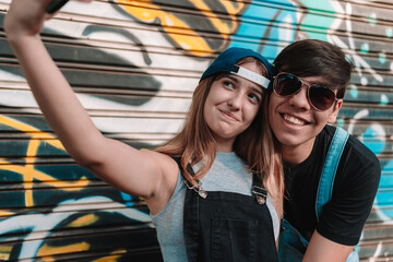 Couple of cool teens taking a selfie.