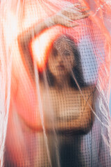 Human trafficking. Defocused portrait. Forced labour. Scared woman hostage trapped behind wrinkled...