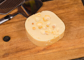 Fototapeta na wymiar Swiss-type cheese on a wooden cutting board