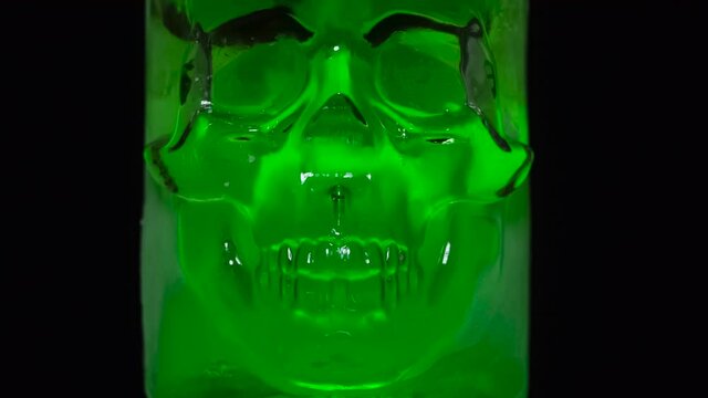 Rapid Melting of Ice Skull. Timelapse. Ice skull covered with frost quickly melts and glistening disappears in the dark