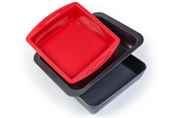 Empty metal nonstick and silicone baking trays on white background