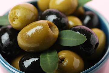Bowl of olives and leaves, close up
