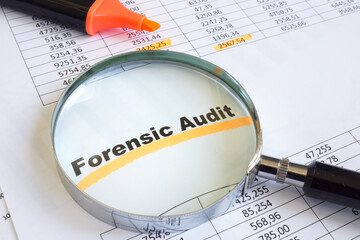 Forensic audit data and magnifying glass on papers.