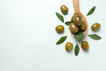 Wooden spoon with olives on white background, space for text